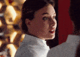 a close up of a woman 's face with a white shirt on