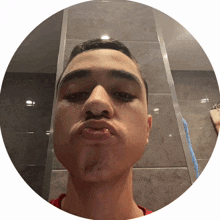 a man in a red shirt is making a funny face in front of a mirror