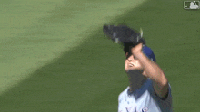 a baseball player with the letter t on his jersey is catching a ball