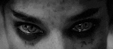 a close up of a person 's eyes with a tattoo on their forehead .