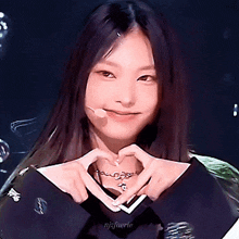a girl is making a heart shape with her hands and the name nijfuerie is on the bottom