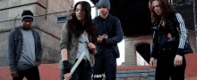 a group of people standing next to each other and one of them is holding a bat .