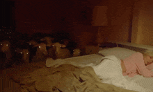 a woman in a pink sweater is sleeping in a bed surrounded by sheep