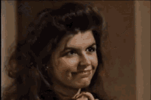 a close up of a woman 's face smiling in a dark room .