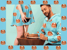 a woman pours syrup on a stack of pancakes while a man looks on