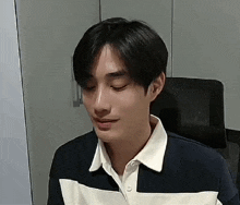 a young man is sitting in a chair with his eyes closed and making a funny face .