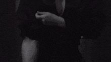 a black and white photo of a woman 's hands with a wedding ring on her finger .