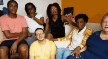 a group of people are sitting on a couch and posing for a picture