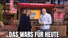 two men are standing next to each other in front of a sign that says das wars für heute .