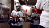 a hockey player in a florida jersey stands in a hallway