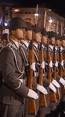 a group of soldiers are standing in a line with guns