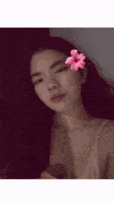 a woman with a flower in her hair looks at the camera