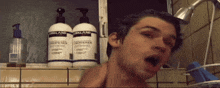 a man taking a shower in front of two bottles of kirkland