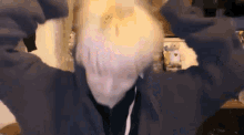 a person with white hair is holding their head in their hands .