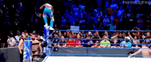 a wrestler is standing on top of a rope in a wrestling ring with a sign that says luigi