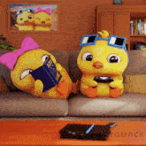two cartoon ducks are sitting on a couch and one is reading a book