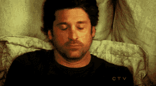 a man is laying in bed with his eyes closed and the letters ctv are visible in the corner