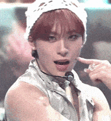 a woman with red hair is wearing a white hat and a microphone around her neck