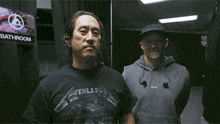 two men are standing next to each other and one of them is wearing a metallica shirt