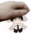 a hand is holding a small doll with wings on it .