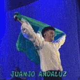 a man holding a flag with the name juanjo andaluz on it