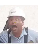 a man wearing a hard hat and suspenders is making a funny face with his mouth open .