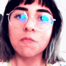a close up of a woman wearing glasses with blue lenses