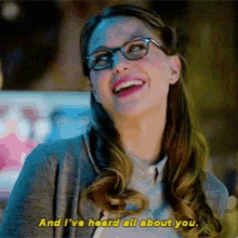 a woman wearing glasses is laughing and saying " and i 've heard all about you "