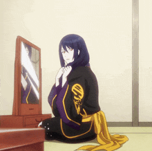 a woman sitting in front of a mirror with a yellow ribbon around her waist