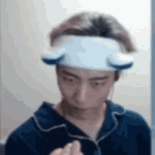 a man wearing a headband with ears on it is looking at himself in the mirror .