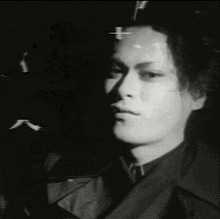 a black and white photo of a man 's face with the letter k in the background .