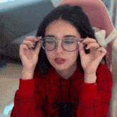 a woman wearing glasses and a red spider man sweatshirt
