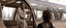 a man in a robe is standing next to another man in a suit .