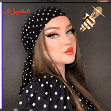 a woman wearing a polka dot head scarf holds a microphone in her hand