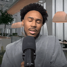 a man is singing into a microphone in an office