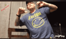a man wearing a blue nirvana shirt is dancing