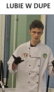 a young man in a white chef 's coat giving a thumbs up