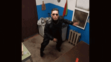 a man in a black leather jacket and sunglasses is standing in a kitchen