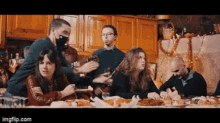 a group of people are sitting around a table eating food .