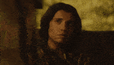 a man in a plaid shirt is sitting in a chair