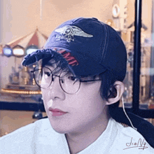 a young man wearing glasses and a baseball cap that says ame