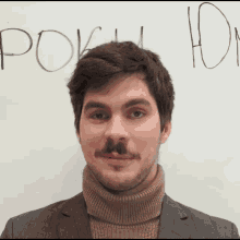 a man with a mustache is standing in front of a white board that says " pok " on it