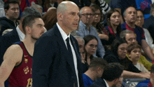 a man in a suit stands next to a basketball player wearing a jersey that says 13