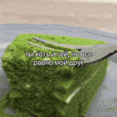 a piece of green cake with a fork sticking out of it .