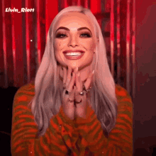 a woman wearing a zebra print sweater is smiling with livin_riott written in the corner