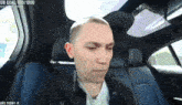 a man is sitting in the back seat of a car with a ub goal of 870/10000