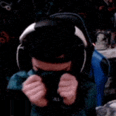 a person wearing headphones is covering their face with a scarf .