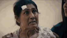 a woman with a bandage on her head is being comforted by another woman