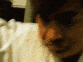 a blurry picture of a man 's face with a white shirt on .