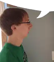 a young man wearing glasses and a green shirt has a speech bubble over his head